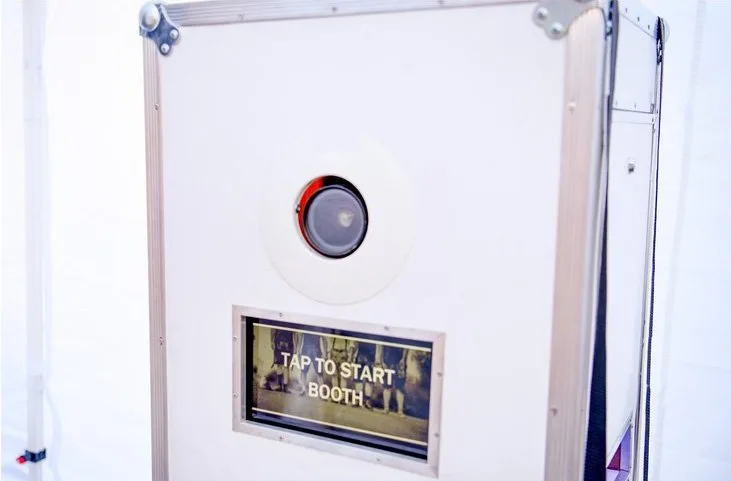 The custom-built open-air Booth-Box photo booth with its camera and Tap To Start screen